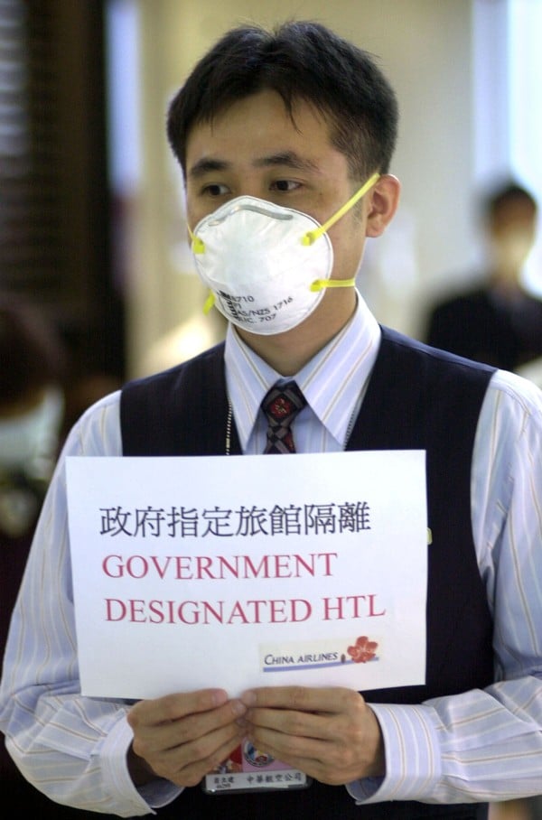 Quarantine notices such as this one, held up by a China Airlines employee at Taipei’s international airport, were common for travellers from Sars-infected places such as Hong Kong in 2003. Photo: AP