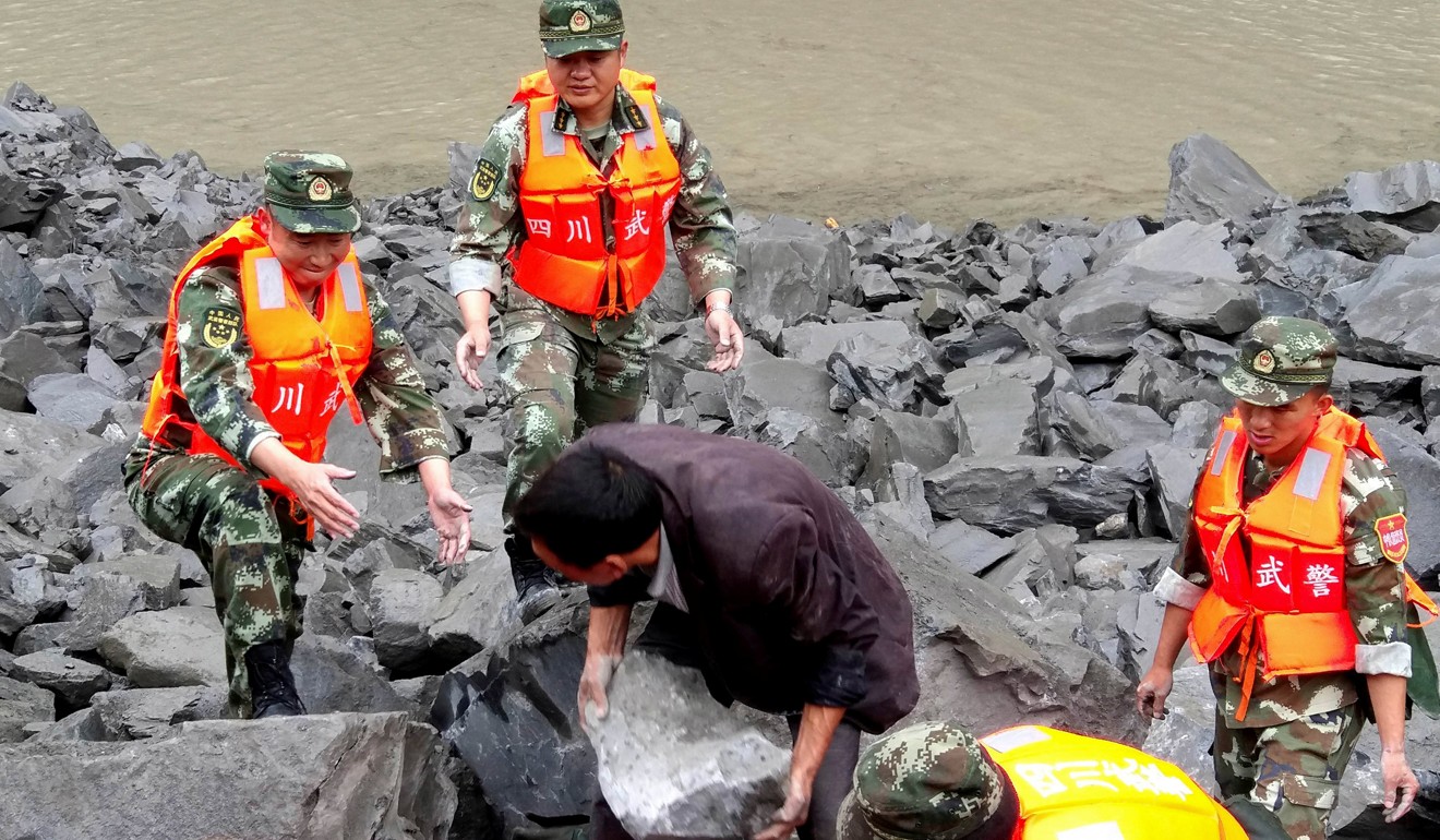 Military police and rescue workers search for survivors using shovels and their hands at the site of a landslide that buried the mountain village of Xinmo in northern Sichuan province. Photo: Reuters