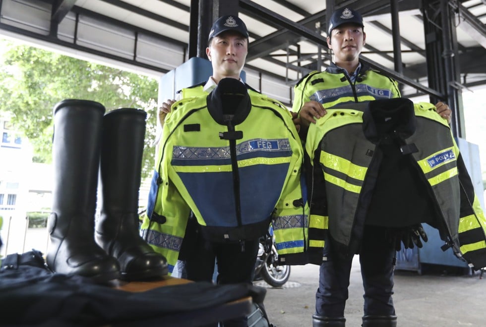 Two police officers display the uniforms they wear when they are on duty. Photo: Nora Tam