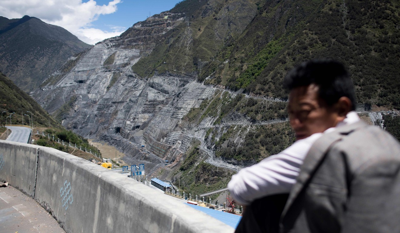 A man sits alongside the construction site of the Lianghekou dam in Sichuan province. Photo: AFP
