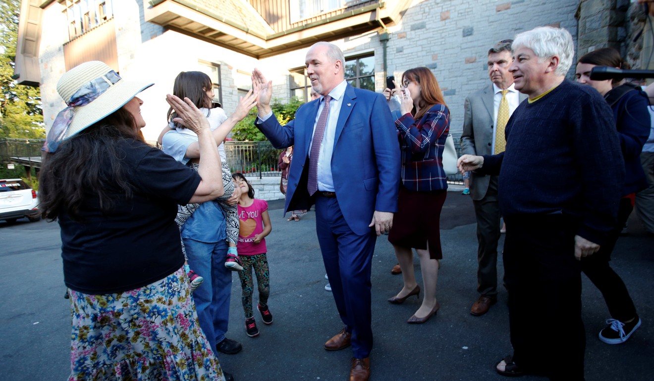 British Columbia Premier-designate John Horgan high-fives supporters after making a statement to the media at Government House on Thursday. Photo: Reuters
