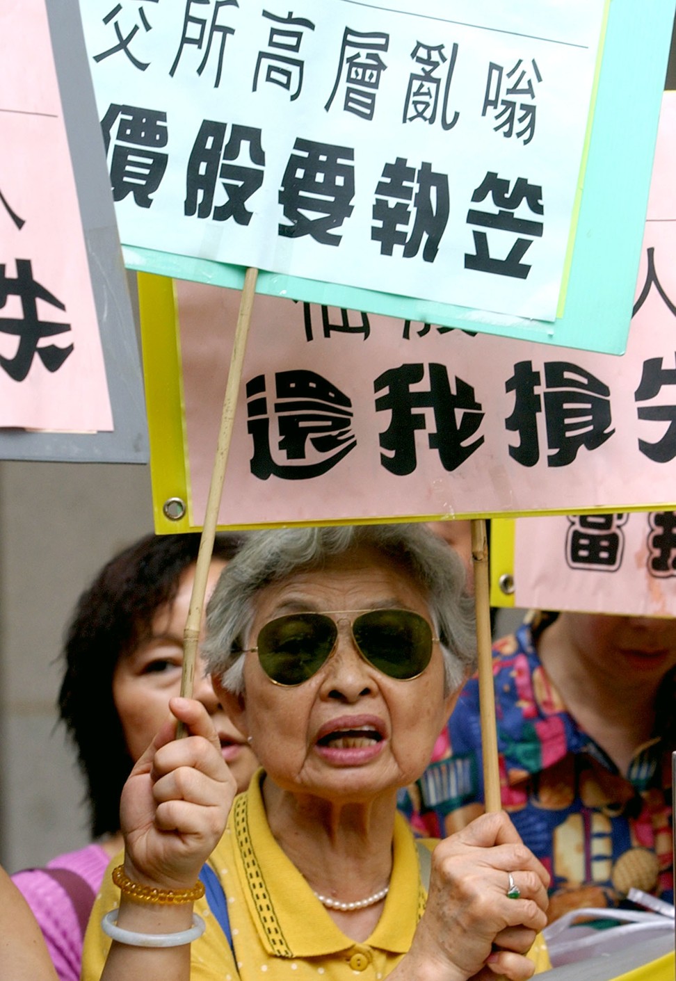 Protesters shout slogans as they stage a rally outside Hong Kong's Legislative Council in July 2002, before the Financial Affairs Panel starts looking into the debacle that slammed Hong Kong's market. With accusations flying over an unfolding stock exchange scandal, lawmakers demanded to know what went wrong when a market reform proposal sparked a massive sell-off of so-called 