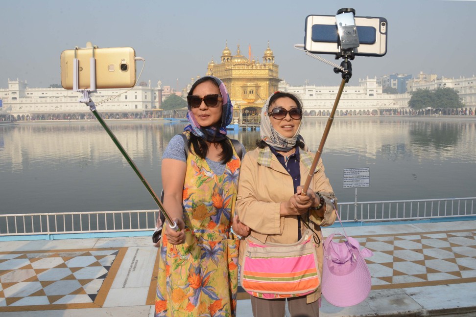 Chinese tourists taking a 'selfie' at the Golden Temple in Amritsar, as Sikh devotees mark the 547th birth anniversary of Sri Guru Nanak Dev. Guru Nanak was the founder of the Sikh religion and the first of ten Sikh gurus. Photo: AFP