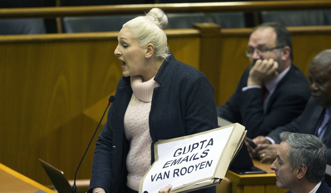 A South African member of the official opposition party, Democratic Alliance, presents printouts of the Gupta emails before giving them to the ruling African National Congress in parliament. Photo: EPA