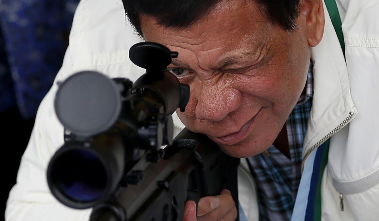 Philippine President Rodrigo Duterte checks the scope of a Chinese-made CS/LR4A sniper's rifle during the ceremonial turnover of thousands of new rifles and more than six million ammunitions by China to the Philippines at Clark Airbase in northern Philippines, on June 28. Duterte has initiated a notable rapprochement with China, paving the way to closer business and trade ties. Photo: AP