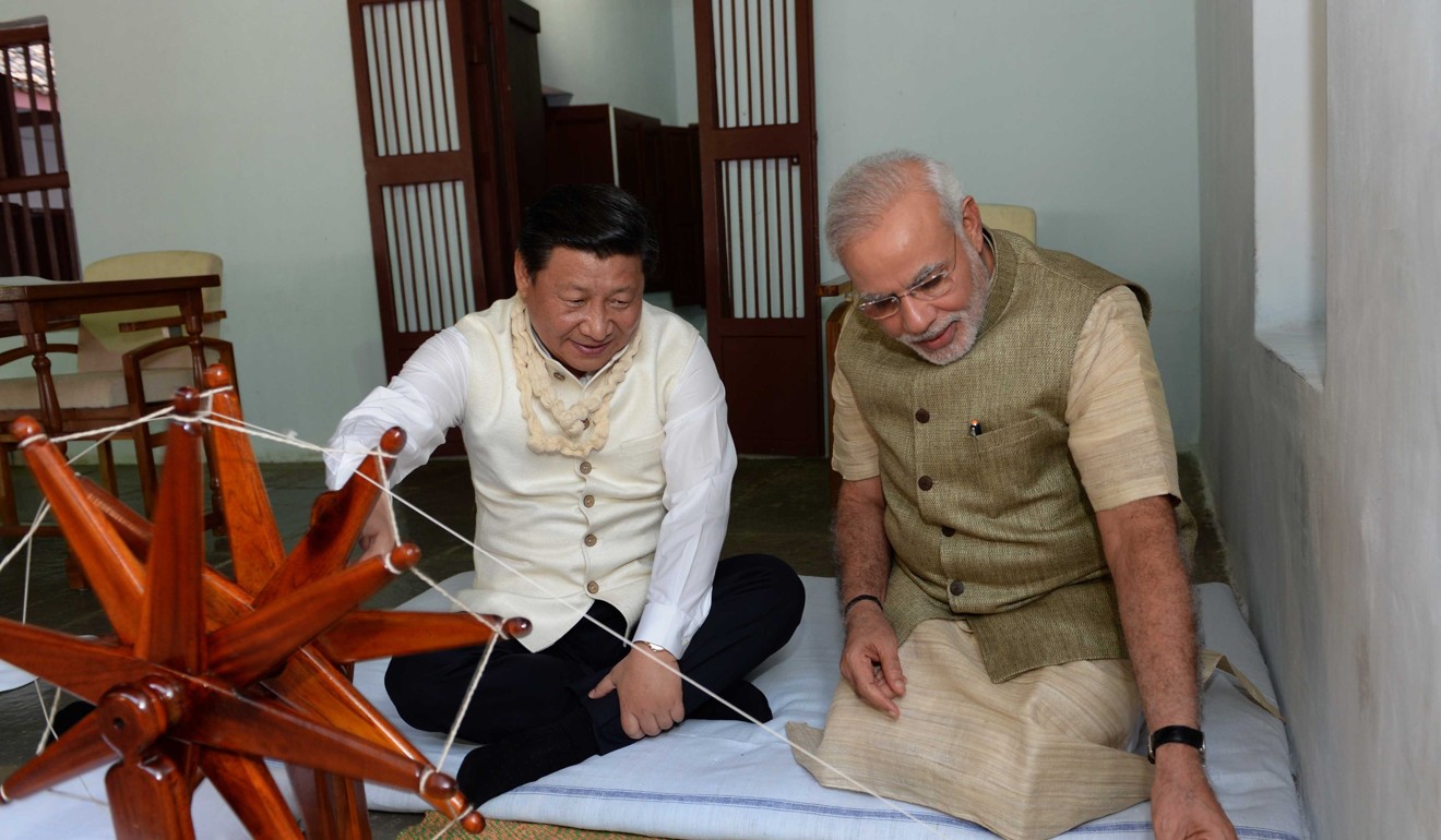 Chinese President Xi Jinping rotates a spinning wheel that was once used by Mahatma Gandhi as he visits Gandhi's former residence along with Indian Prime Minister Narendra Modi in Gujarat, India. Photo: Xinhua