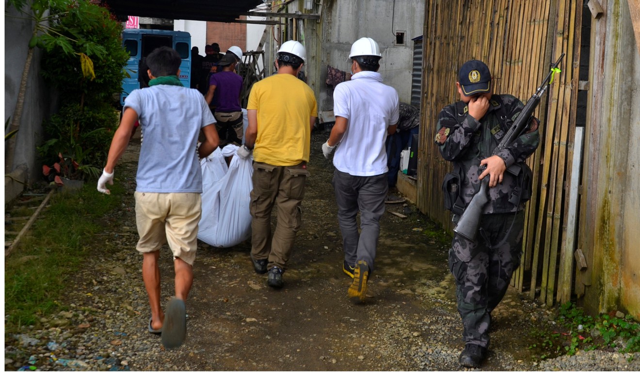 A group of rescue volunteers carry a body they found at the beginning of the fight between government troops and Maute militants in Marawi, Philippines. Photo: Reuters