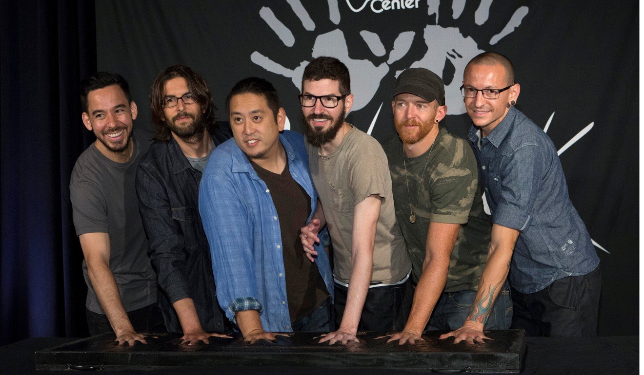 Members of rock band Linkin Park (L-R) Mike Shinoda, Rob Bourdon, Joe Hahn, Brad Delson, Dave Farrell and Chester Bennington put their handprints in cement as they are inducted into Guitar Center's RockWalk in Los Angeles in 2014. Photo: Reuters