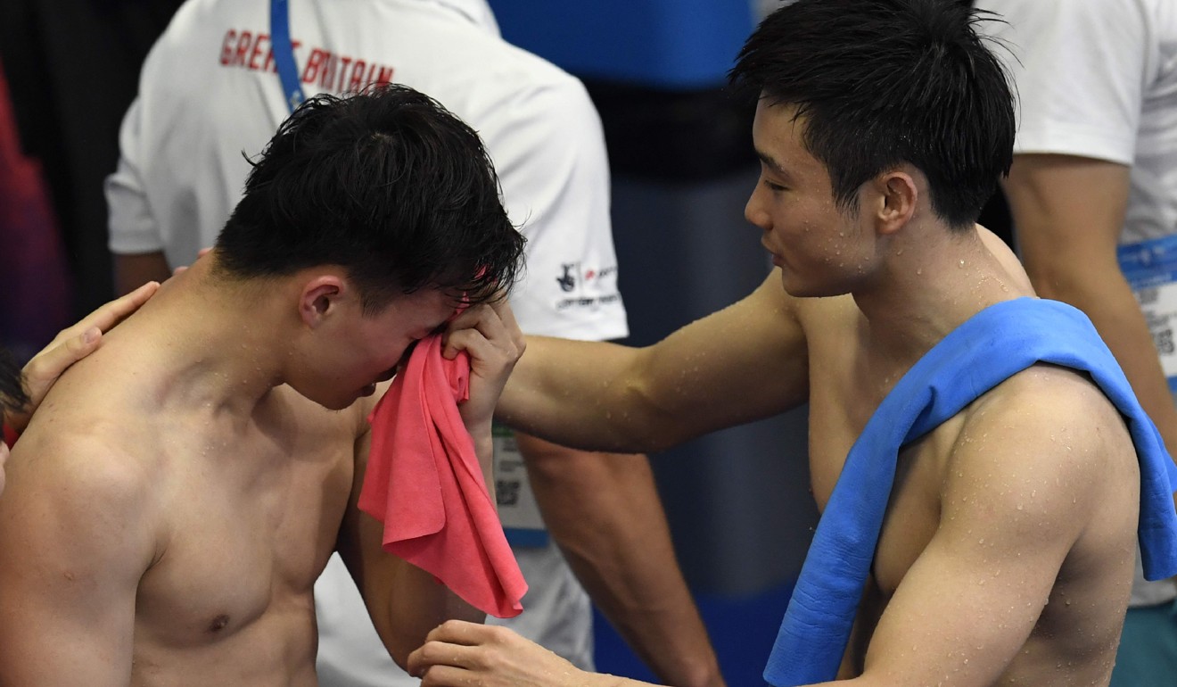 Xie Siyi (left) is congratulated by Cao Yuan after winning the gold medal in the men's 3m springboard final. Photo: AFP