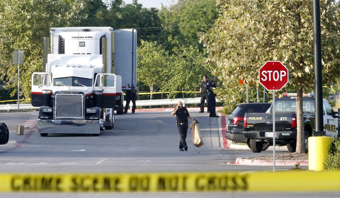 Law enforcement attends the scene where people were discovered dead inside a semi-trailer in a Walmart parking lot in San Antonio. Photo: TNS