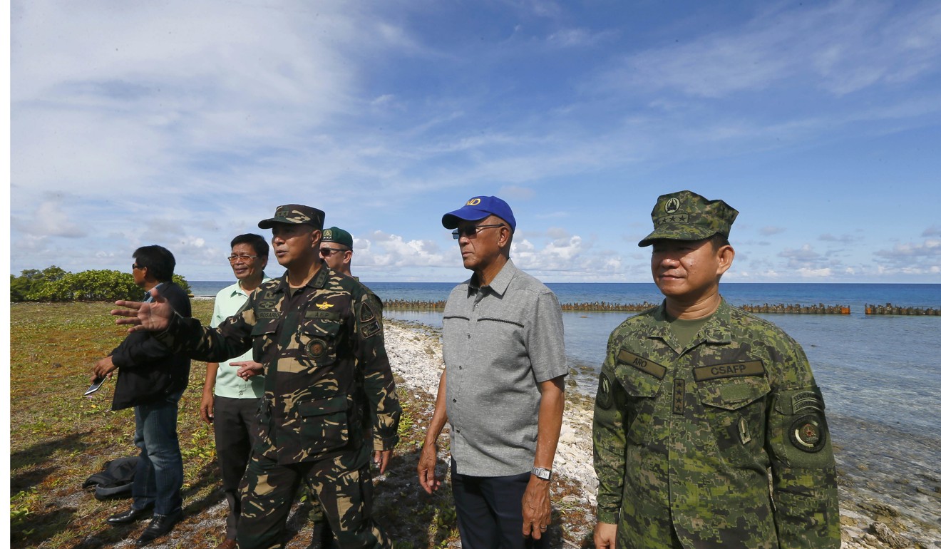 Philippine Defense Chief Delfin Lorenzana, second from right, and other officials inspect the end of the airstrip during their visit to Thitu Island off the South China Sea. Photo: Associated Press