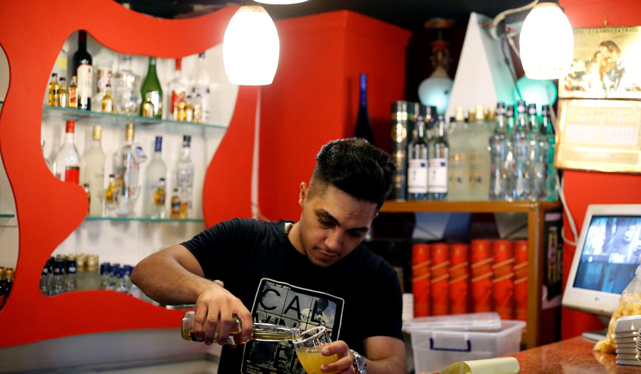 A man pours drinks at a bar in the town of Qaraqosh, south of Mosul. Photo: Reuters