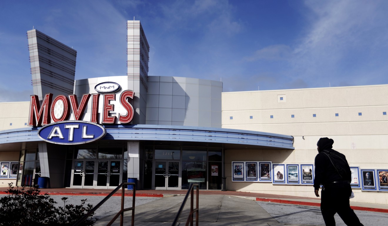 A patron walks into a Carmike Cinemas movie theatre in Atlanta. AMC Entertainment acquired rival chain Carmike Cinemas for US$1.1 billion including debt. Photo: AP
