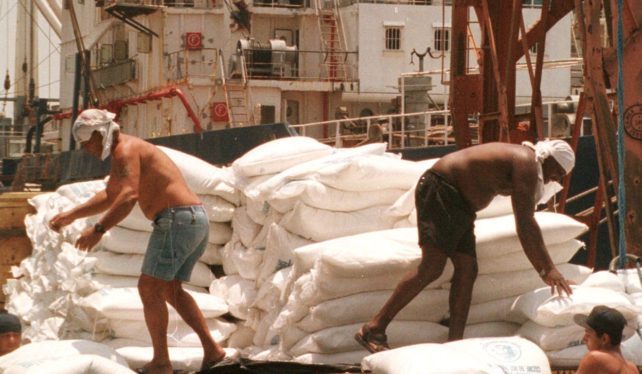 In a file photo, Workers load sacks of sugar onto ships at the port of Santos, about 50 miles southeast of Sao Paulo, Brazil. Photo: AP