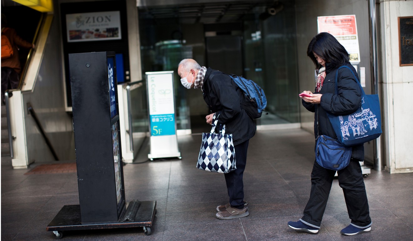 An elderly man looks at the menu of a restaurant in the Ginza shopping district of Tokyo. Photo: AFP