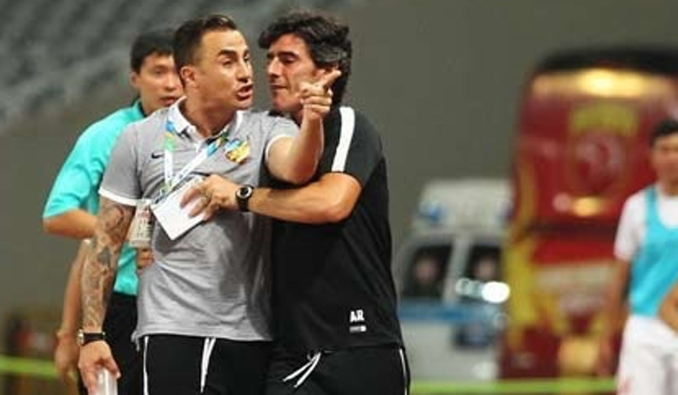 Fabio Cannavaro is restrained by a member of his back room staff.