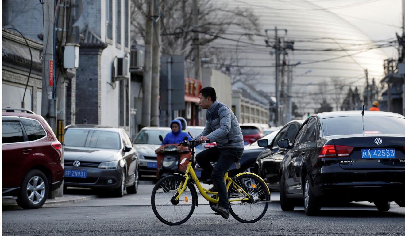 A man rides one of Ofo’s signature yellow bikes near the National Grand Theatre in central Beijing. Photo: Reuters