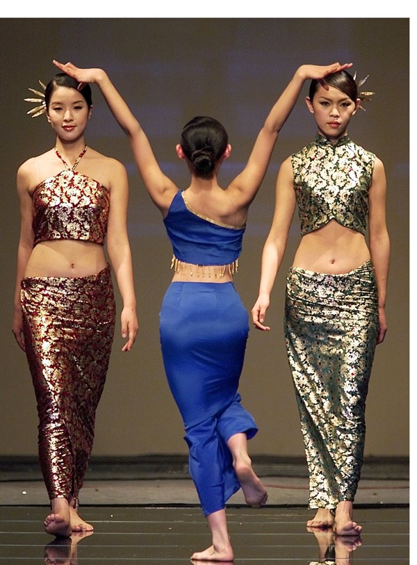 Models display dresses inspired by China's ethnic minority costumes during a fashion show called 