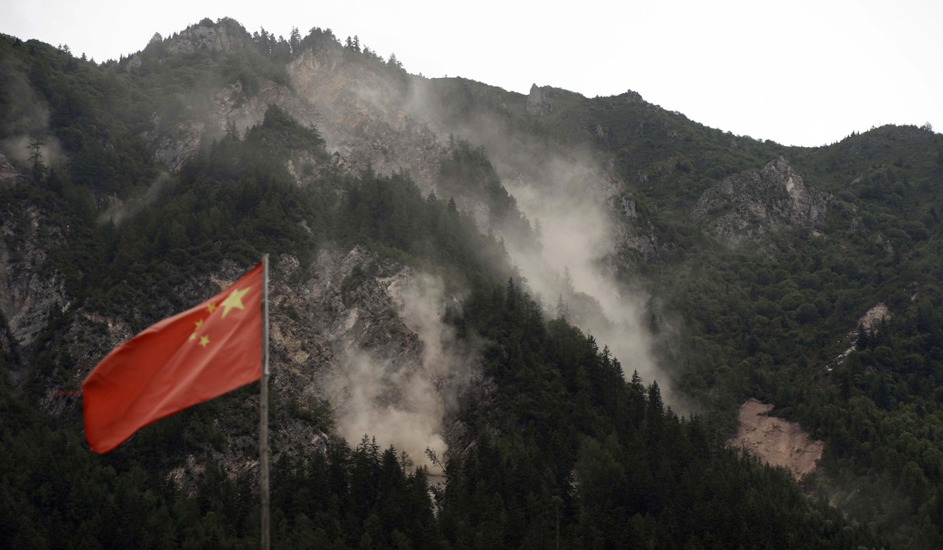 Rocks and dust roll down a hillside in Jiuzhaigou following an aftershock two days after the earthquake. Photo: AFP