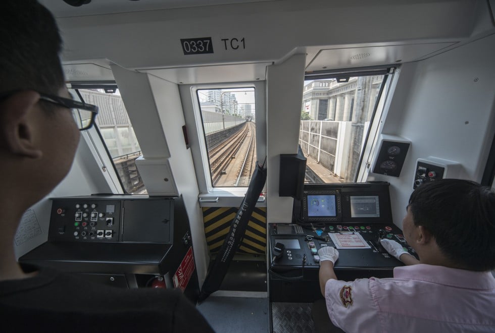 Driver Fei Chaoxia (right) and an intern operate a train on Line 3.