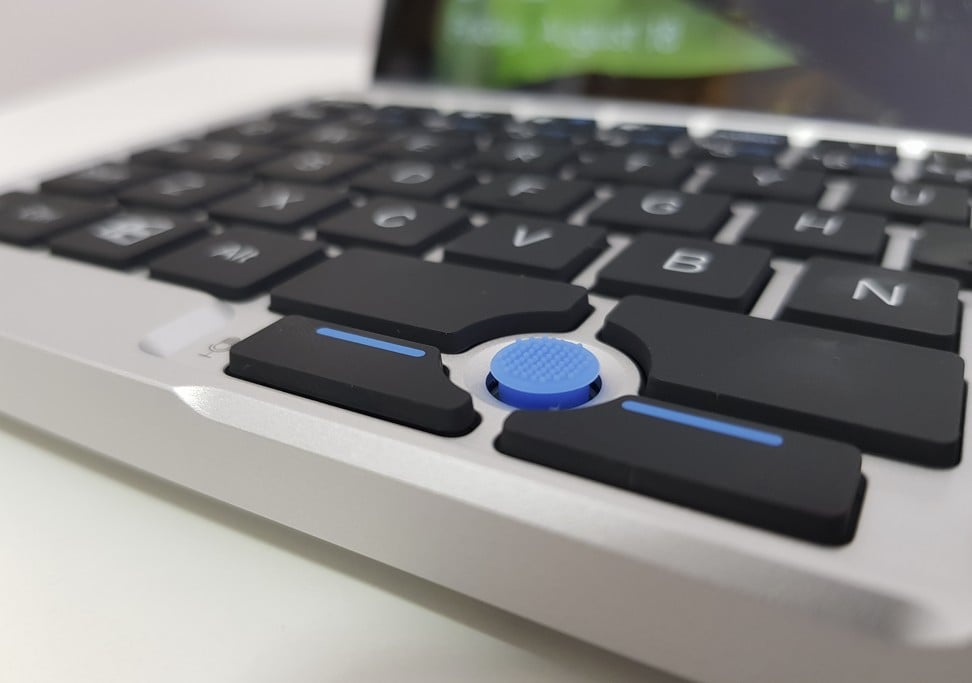The blue rubber nub is a pointing stick that allows the user to control the mouse arrow. Below the pointing stick are dedicated left and right mouse buttons. Photo: Ben Sin