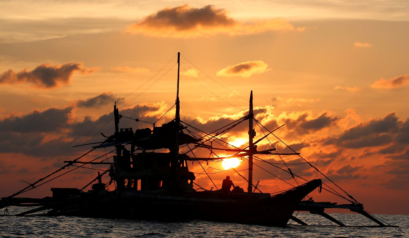 A Philippine boat fishes during sunset at the disputed Scarborough Shoal in the South China Sea. Photo: Reuters
