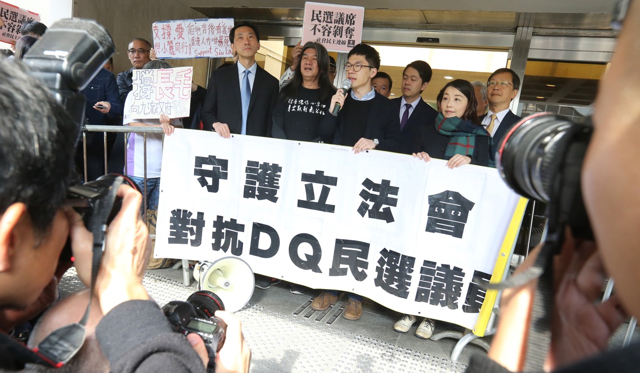 Disqualified Hong Kong lawmakers (holding banner) Edward Yiu Chung-yim, “Long Hair” Leung Kwok-hung, Nathan Law Kwun-chung and Lau Siu-lai outside the High Court in Admiralty. Photo: Dickson Lee