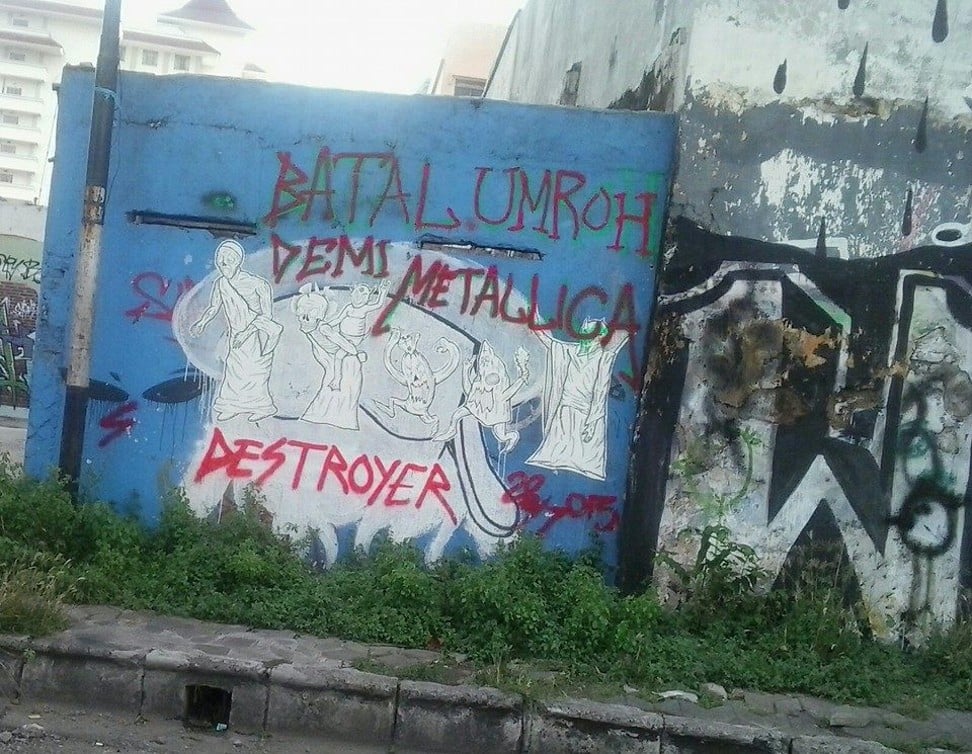 Street graffiti that reads: “I cancelled my Umroh [Islamic pilgrimage to Mecca] to see Metallica” sprayed on a wall behind a mosque in Surakarta, Indonesia. Photo: Yuka Narendra