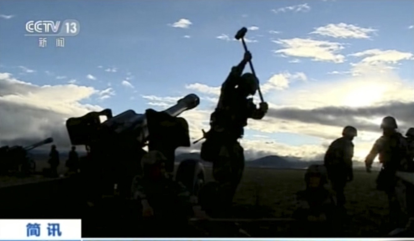 Chinese television shows soldiers preparing artillery guns during a live-fire drill in Tibet, on the border with India. Photo: AP