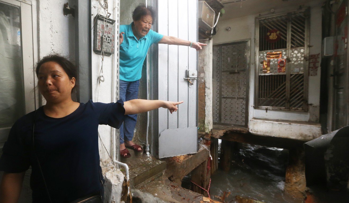 Distressed residents point to their damaged home. Photo: Sam Tsang