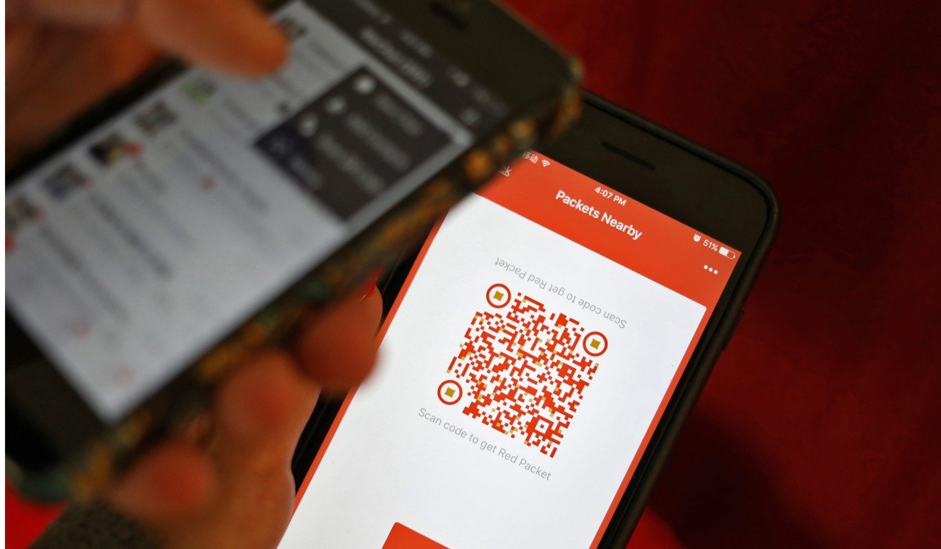 A WeChat user scans a QR code to retrieve a digital red envelope on a mobile phone during the Chinese New Year. In mobile internet applications, China’s tech firms are taking the lead. Photo: EPA