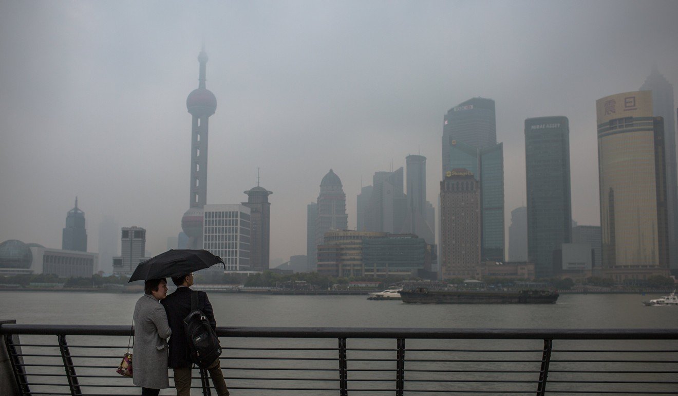 Tourists on the Bund look at the Pudong skyline through heavy smog during a rainy and polluted day, in Shanghai in April. Photo: EPA