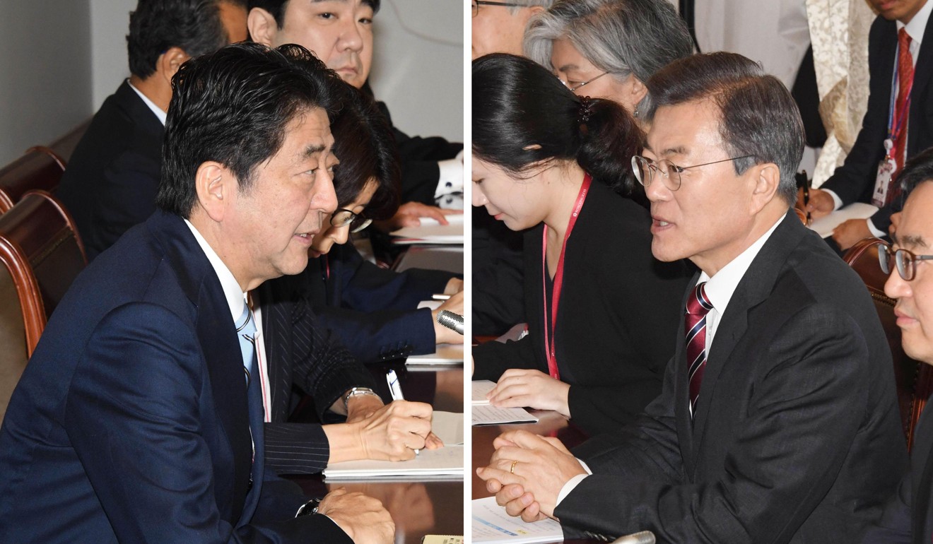 Japanese Prime Minister Shinzo Abe (L) and South Korean President Moon Jae-in hold talks. Photo: Kyodo