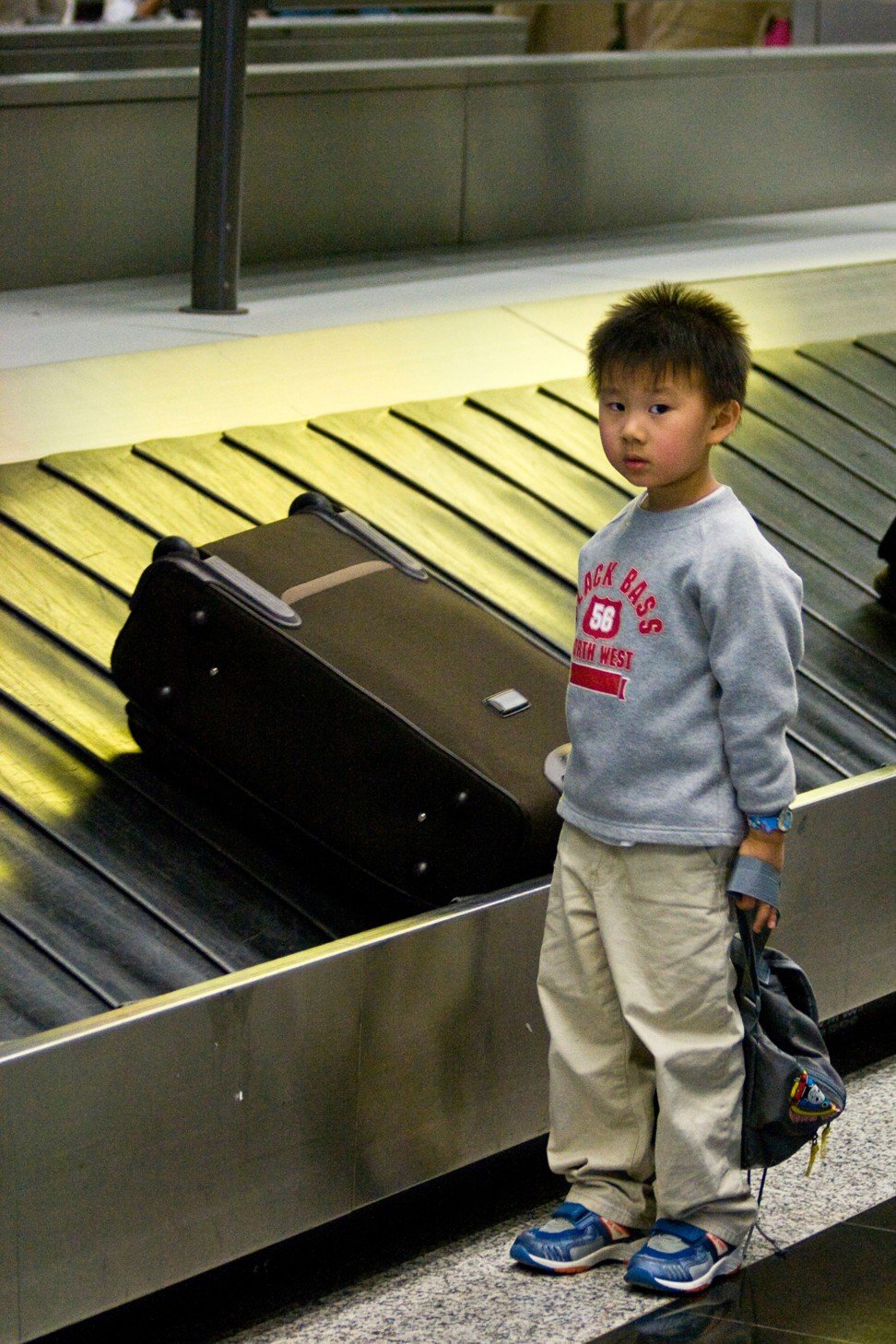 A young boy at Hong Kong baggage claim. Photo: Alamy