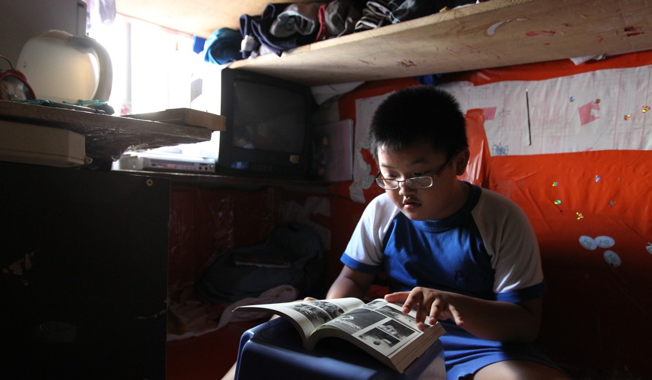 Simon Pun Shun-sai, eight, does his homework in a 50 sq ft slab-type apartment. Housing remains the most pressing issue for many families. Photo: Dickson Lee