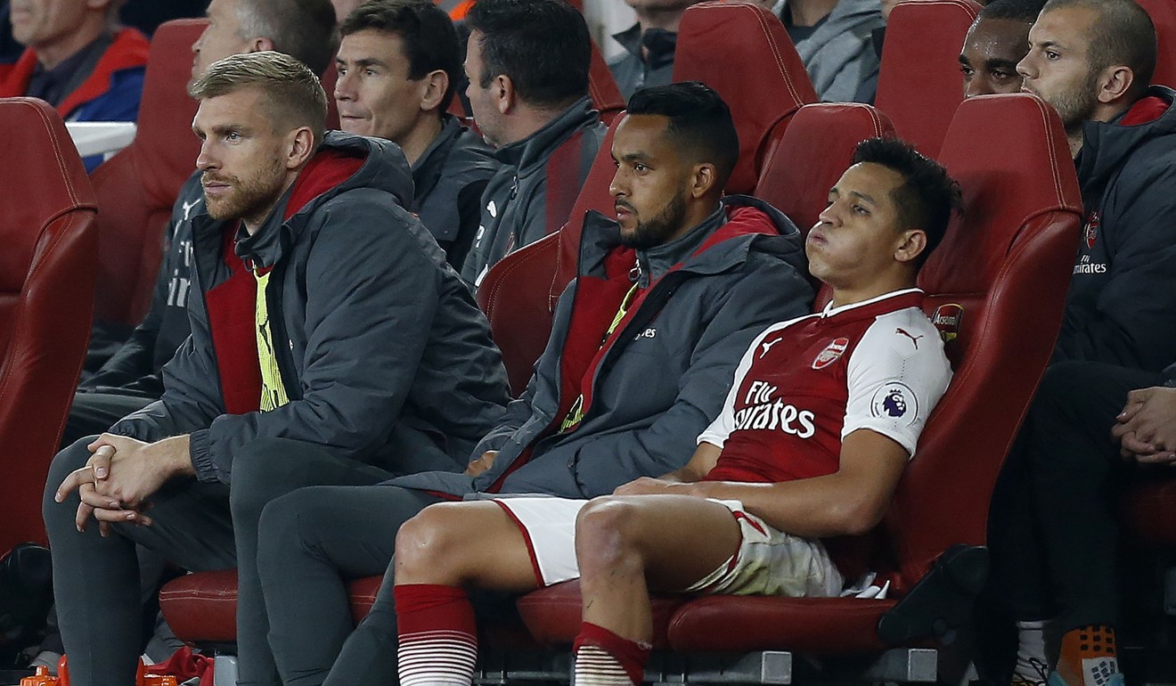 Arsenal's Chilean striker Alexis Sanchez (R) reacts as he sits in the dug out after being substituted. Photo: AFP