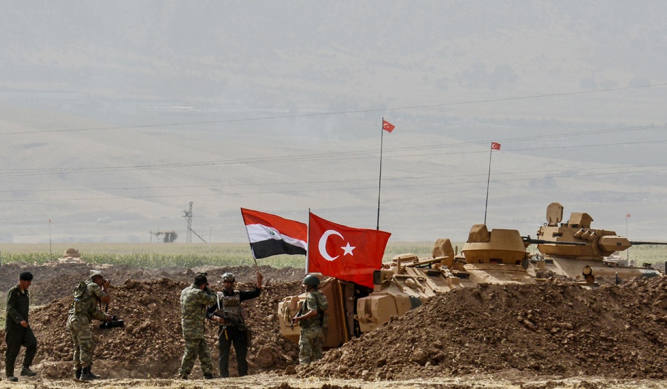 Soldiers stand next to tanks bearing Turkish and Iraqi flags during a joint military exercise near the Turkish-Iraqi border at Silopi district in Sirnak on September 26, 2017. Turkey launched a military drill with tanks close to the Iraqi border the army said, just as Iraq's Kurdish region held an independence referendum on September 25. Photo: AFP