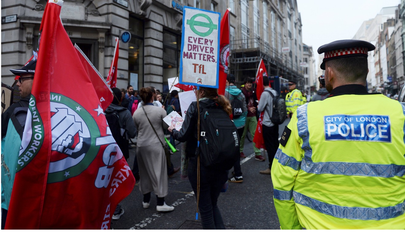 A police officer keeps an eye on a protest against Uber and in favour of labour rights in central London. Photo: Reuters