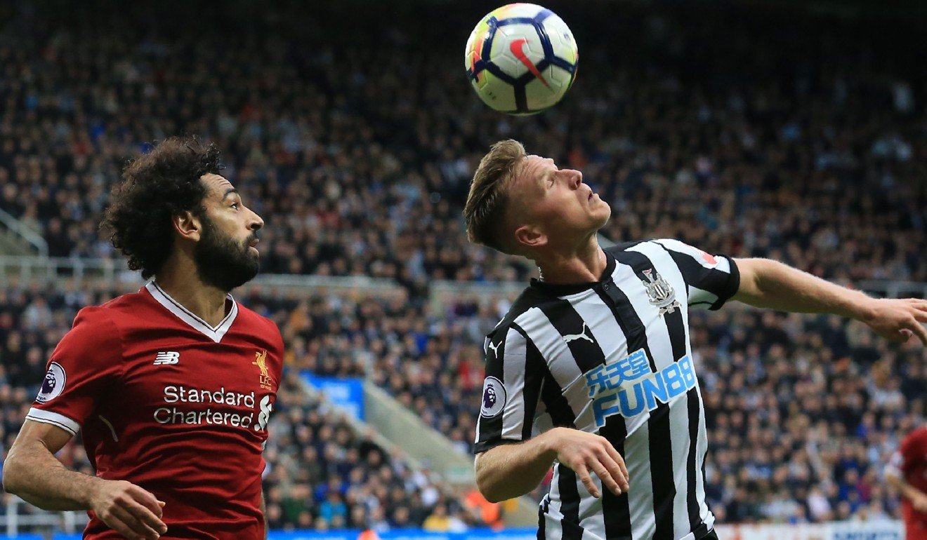 Newcastle midfielder Matt Ritchie gets to ball ahead of Mohamed Salah. Photo: AFP