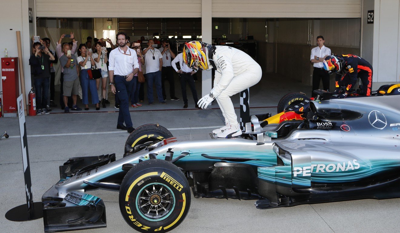 Lewis Hamilton stands on his car after taking out the Japan Grand Prix.