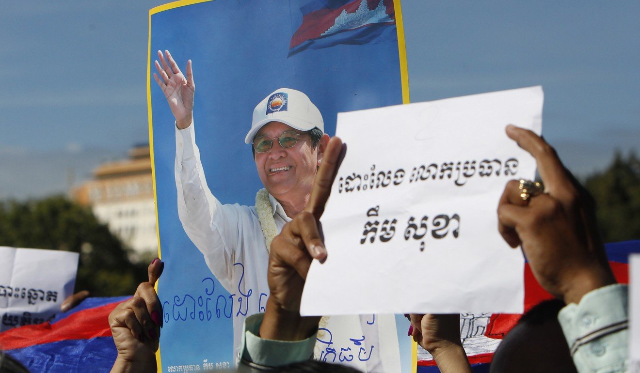 Supporters of the opposition Cambodia National Rescue Party hold up a portrait of the party leader Kem Sokha and slogans that read: ‘Free Kem Sokha’ during a rally near an appeals court in Phnom Penh. Photo: AP