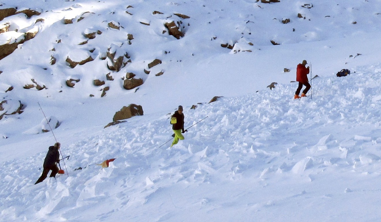 Searchers probe the lower portion of an avalanche debris field. Photo: AP