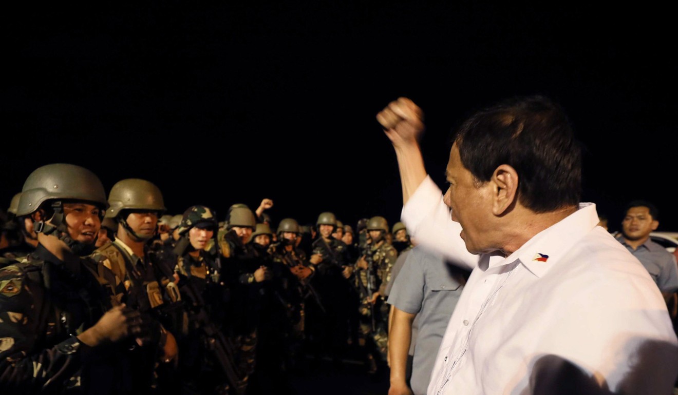Philippine President Rodrigo Duterte salutes government troops as they travel home from their combat duty against pro-Islamic State militants. Photo: EPA
