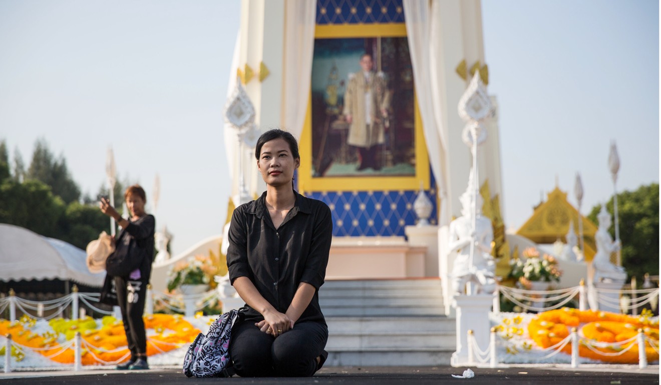 A mourner kneels near the King Rama I Monument during the cremation ceremony of the late King Bhumibol Adulyadej in Bangkok. Photo: Bloomberg