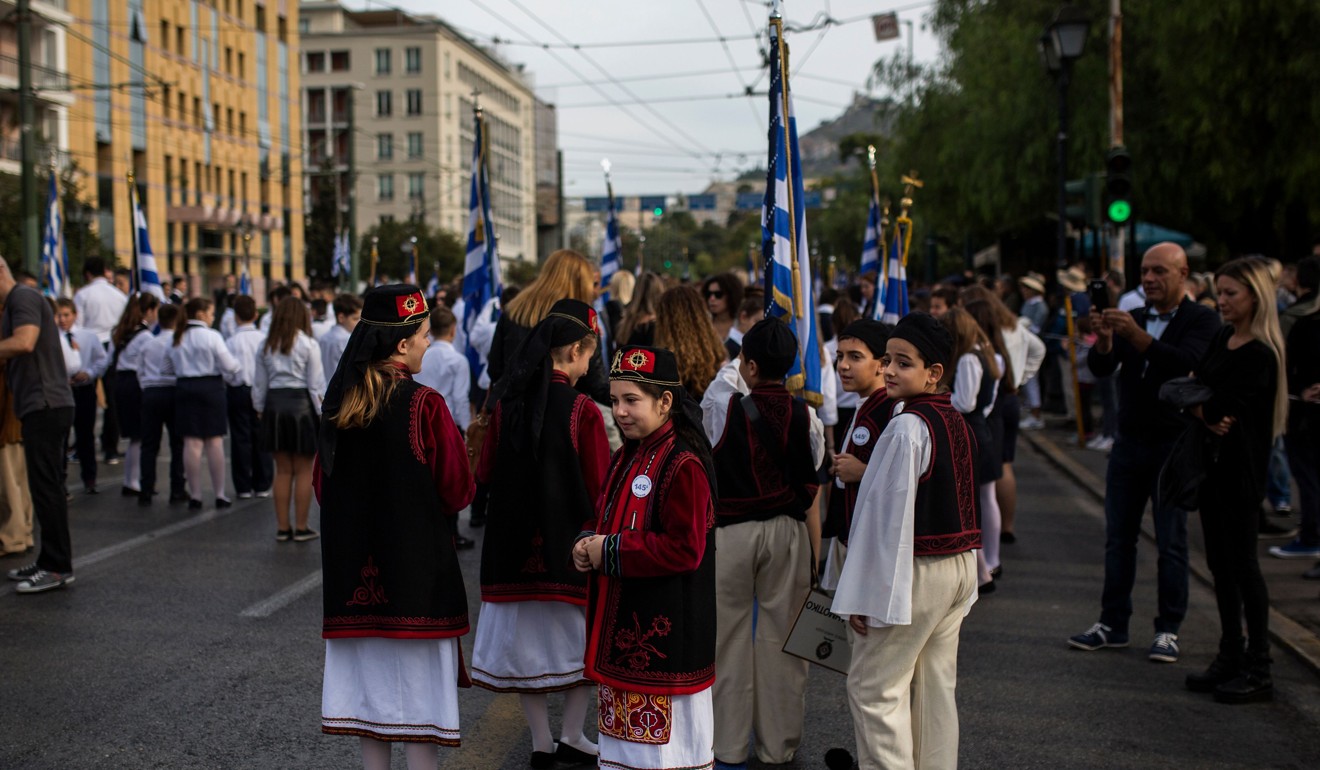 Children with traditional costumes wait to start a parade in central Athens. Photo: Agence France-Presse