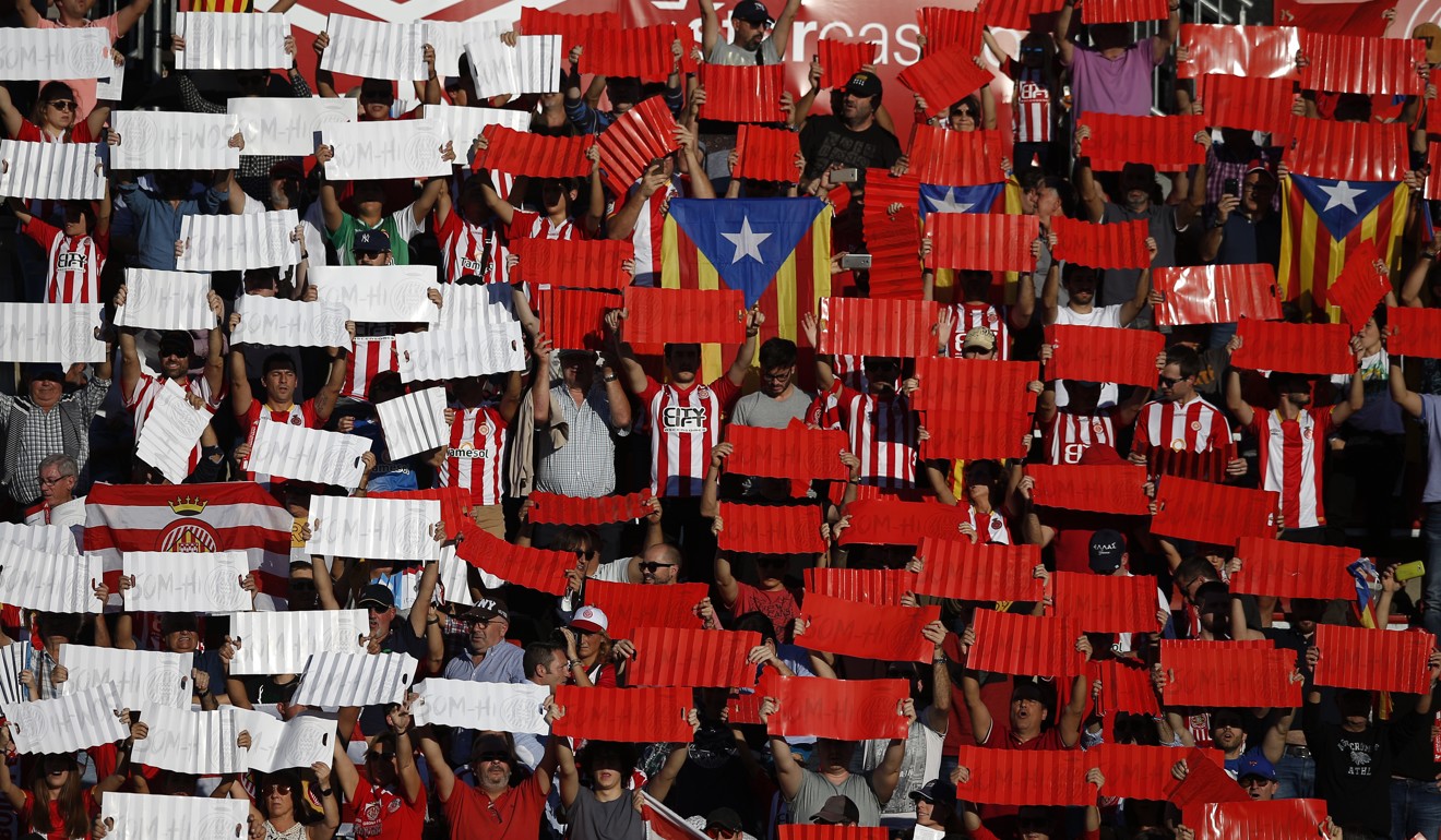 Supporters of the Girona soccer team hold up placards in their teams colours and Catalan flags prior to the start of the La Liga soccer match between Girona and Real Madrid at the Montilivi stadium in Girona on Sunday. Photo: AP