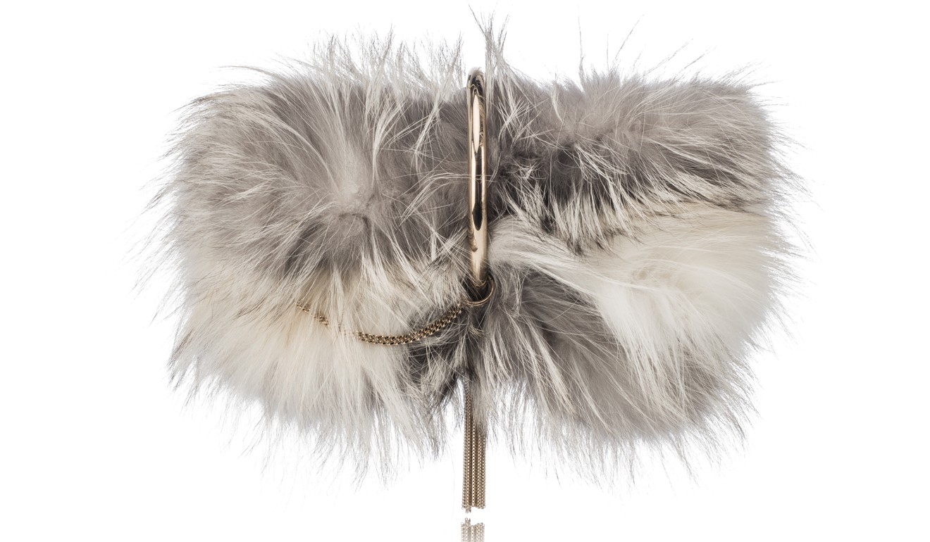 The Charley clutch, in moonstone metallic tipped fox fur, comes with a metal bracelet which can be worn on the wrist.