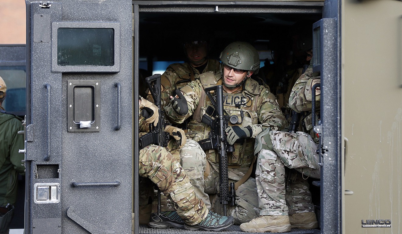 Law enforcement personnel load into a vehicle to search for the gunman. Photo: AP