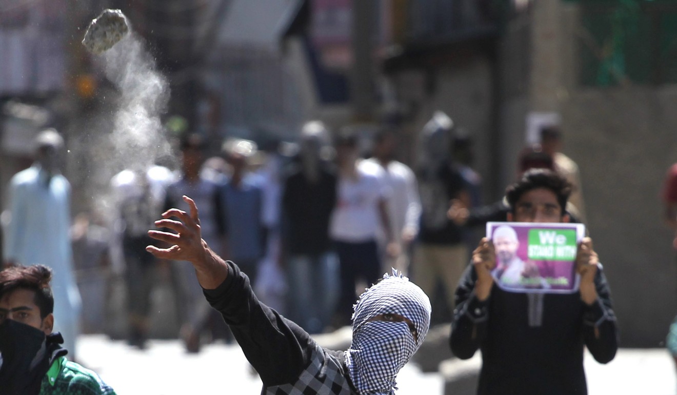 Kashmiri masked protesters throw stones at Indian police as one holds a poster of Islamist preacher Zakir Naik during a protest in Srinagar, summer capital of Indian-controlled Kashmir in 2016. File photo: Xinhua