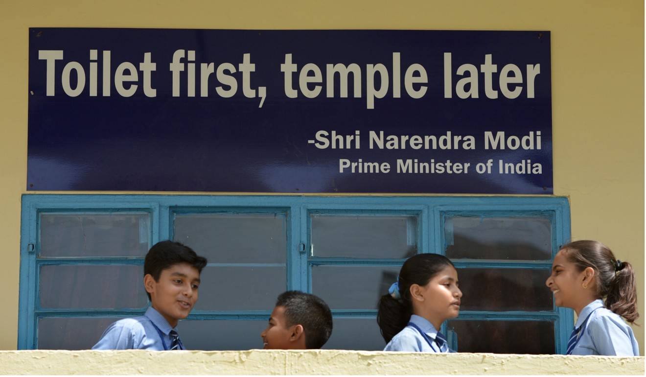 Indian schoolchildren talk in front of a poster with a quote from Prime Minister Narendra Modi. Photo: AFP